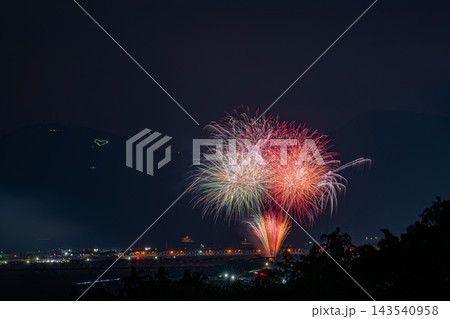 金谷の高台から見下ろす大井川大花火大会の夜空に映える鮮やかなスターマインと夜景風景(静岡県) 金谷の高台から見下ろす大井川大花火大会の夜空に映える鮮やかなスターマインと夜景風景(静岡県) 143540958