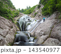 秋田県北秋田市・桃洞の滝　滑らかな岩盤の滝で遊ぶ人 143540977