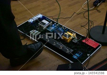 床に置かれたペダルボードに並ぶギター用エフェクターと足元 床に置かれたペダルボードに並ぶギター用エフェクターと足元 143541598