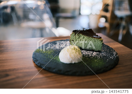 石のプレートにのった抹茶のバスクチーズケーキとアイス 143541775