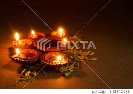 Traditional clay diyas illuminating Diwali festival of lights Traditional clay diyas illuminating Diwali festival of lights 143542181