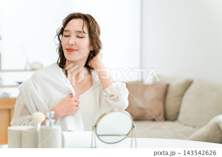 お風呂上がりにタオルを肩にかけ、目を閉じてリラックスする女性。家での美容・ヘアケア・スキンケア習慣 143542626