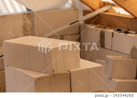 Lightweight aerated concrete blocks piled up at a construction site, forming a wall in progress and highlighting the essential materials for building and renovation projects 143544268