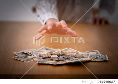 お金に手を伸ばす男性 暗い お金に手を伸ばす男性 暗い 143546087