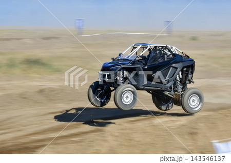 ダートコースでジャンプする黒いオフロードバギーの流し撮り ダートコースでジャンプする黒いオフロードバギーの流し撮り 143546137