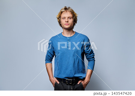 Confident young blonde man with hands in pockets portrait Confident young blonde man with hands in pockets portrait 143547420