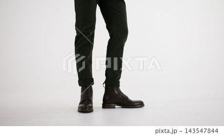 Man wearing dark green chinos and brown leather lace-up boots, showcasing autumn and winter fashion style 143547844