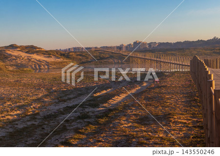 Scenic view of a long wooden footbridge path crossing a coastal lagoon in the morning light on the Camino de Santiago pilgrimage route in Portugal 143550246