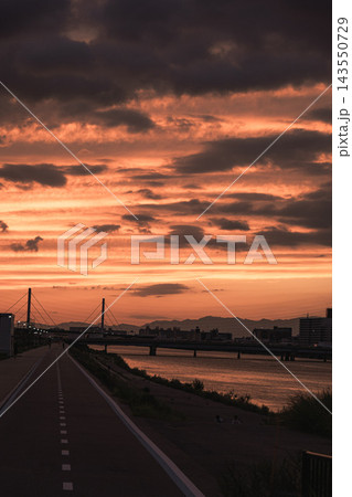 縦構図の遊歩道と燃える夕空 143550729