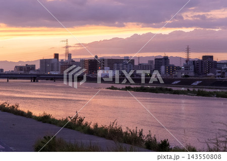 紫とオレンジが混ざり合う川辺の夕景 143550808