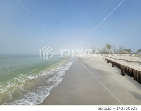 Misty Tropical Beach With Gentle Waves Washing Ashore 143550925