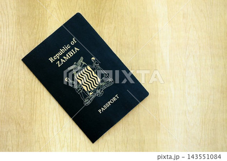 Zambian passport on table close up. Official identification document book for citizens of Zambia. Concept of travel and tourism in Zambia Zambian passport on table close up. Official identification document book for citizens of Zambia. Concept of travel and tourism in Zambia 143551084