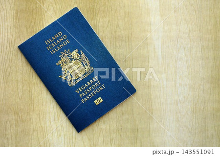 Icelandic passport on table close up. Official identification document book for citizens of Iceland. Concept of travel and tourism in Iceland Icelandic passport on table close up. Official identification document book for citizens of Iceland. Concept of travel and tourism in Iceland 143551091