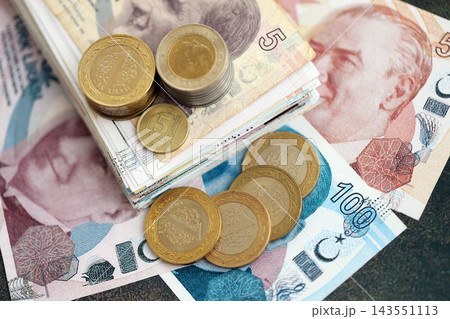 Turkish lira money bills and kurus coins pile on table. Turkey coins on banknotes of TRY currency close up. Concept of business, taxes and banking in Turkey Turkish lira money bills and kurus coins pile on table. Turkey coins on banknotes of TRY currency close up. Concept of business, taxes and banking in Turkey 143551113