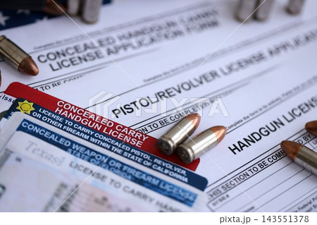USA firearms license and handgun with bullets on US Constitution. Gun permit USA firearms license and handgun with bullets on US Constitution. Gun permit 143551378