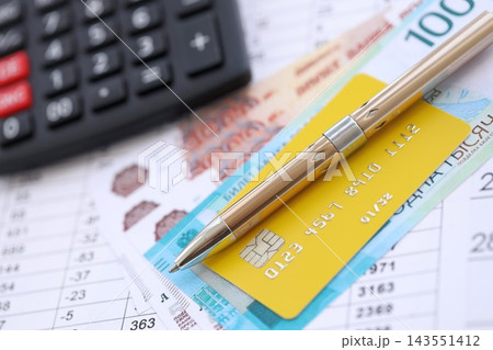 Credit card and pen with russian ruble currency money bills banknotes on calculations document Credit card and pen with russian ruble currency money bills banknotes on calculations document 143551412