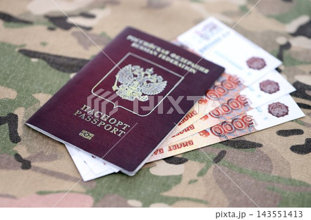 Russian passport with money on multicam camouflage fabric close up. Concept of russian army funds 143551413
