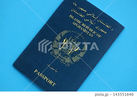 Afghan passport on table. Official identification document book for citizens of Afghanistan Afghan passport on table. Official identification document book for citizens of Afghanistan 143551640