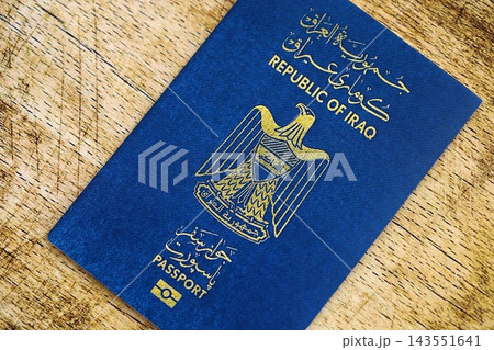 Iraqi passport on table close up. Official identification document book for citizens of Iraq Iraqi passport on table close up. Official identification document book for citizens of Iraq 143551641