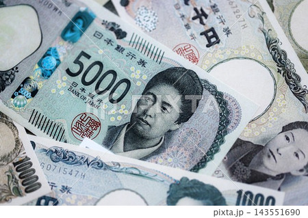 Japanese yen money bills pile on table. Japan banknotes of JPY currency. Concept of business Japanese yen money bills pile on table. Japan banknotes of JPY currency. Concept of business 143551690