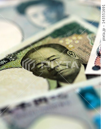 Japanese yen money bills pile on table. Japan banknotes of JPY currency. Concept of business Japanese yen money bills pile on table. Japan banknotes of JPY currency. Concept of business 143551691