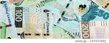 Zambian kwacha money bills pile on table. Zambia banknotes of ZMW currency close up Zambian kwacha money bills pile on table. Zambia banknotes of ZMW currency close up 143551692