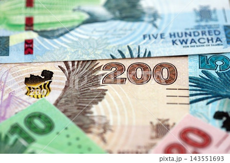 Zambian kwacha money bills pile on table. Zambia banknotes of ZMW currency close up Zambian kwacha money bills pile on table. Zambia banknotes of ZMW currency close up 143551693