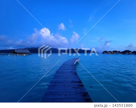Wooden Pier Leading Into Deep Blue Ocean 143551800