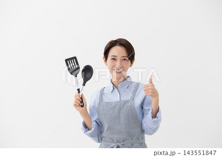 ターナーとスパチュラを持つ女性の料理イメージ ターナーとスパチュラを持つ女性の料理イメージ 143551847