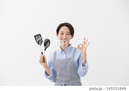 ターナーとスパチュラを持つ女性の料理イメージ ターナーとスパチュラを持つ女性の料理イメージ 143551849