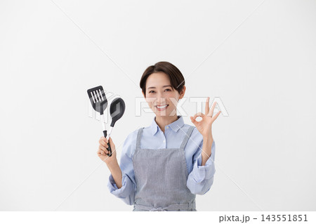 ターナーとスパチュラを持つ女性の料理イメージ ターナーとスパチュラを持つ女性の料理イメージ 143551851