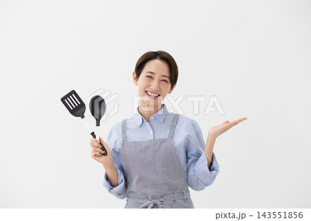ターナーとスパチュラを持つ女性の料理イメージ 143551856