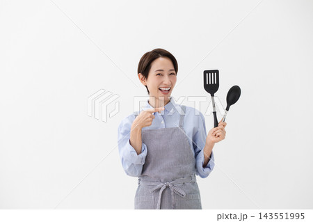 左手にターナーとスパチュラを持つ女性の料理イメージ 143551995