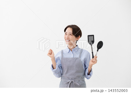 ターナーとスパチュラを持つ女性の料理イメージ ターナーとスパチュラを持つ女性の料理イメージ 143552003