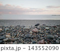 朝焼けの海岸の砂利の中にぽつんと佇むハートの形をしたかわいいピンク色の石 マクロ撮影 143552090