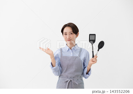 左手にターナーとスパチュラを持つ女性の料理イメージ 143552206