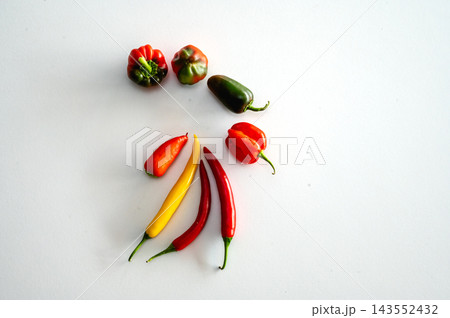 Small Selection of Fresh Colourful Peppers. A small selection of fresh chili and sweet peppers in red, yellow and green on a clean white background, a colourful assortment of spicy vegetables and heal Small Selection of Fresh Colourful Peppers. A small selection of fresh chili and sweet peppers in red, yellow and green on a clean white background, a colourful assortment of spicy vegetables and heal 143552432