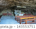 Interior view of the historic Wildkirchli cave chapel with wooden benches and stone altar inside a mountain cave in the Alpstein region, Switzerland 143553751