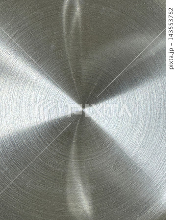 Brushed metal surface with concentric circular grooves radiating from center point and light reflections forming bright and dark sectors Brushed metal surface with concentric circular grooves radiating from center point and light reflections forming bright and dark sectors 143553782
