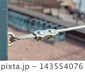 Steel wire rope clamp and cable connection on industrial safety barrier 143554076