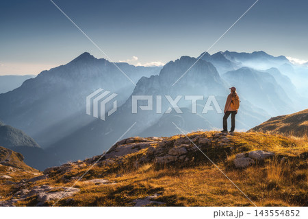 Woman with backpack and mountains in fog in autumn at sunset 143554852