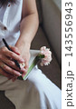 Hand with ring holding a pen and a carnation. Love letter, feelings and tenderness. 143556943