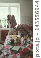 Woman hugging her poodle near the kitchen window. Affection, loyalty and pets as family. 143556944