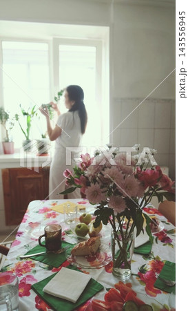 Woman with a fluffy dog in a bright kitchen. Companionship and happy pet ownership. 143556945