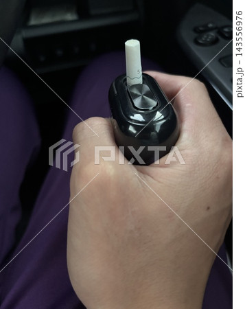 車内で電子タバコを持つ男性の手元 143556976
