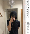 サウナハットをかぶり鏡越しにスマートフォンを持つ男性 143557008