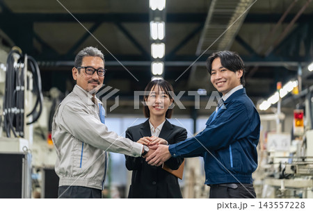 工場で握手する作業員グループ。事業承継、提携、取引、M&A、仲介、紹介、製造業、団結、サポート、協力 143557228