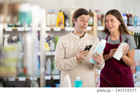 Girl seller help man visitor scan QR code, get information about shampoo in mobile app Girl seller help man visitor scan QR code, get information about shampoo in mobile app 143559377