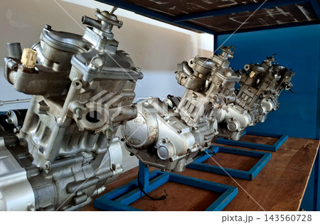 Row of Motorcycle Engines on Workshop Racks Row of Motorcycle Engines on Workshop Racks 143560728