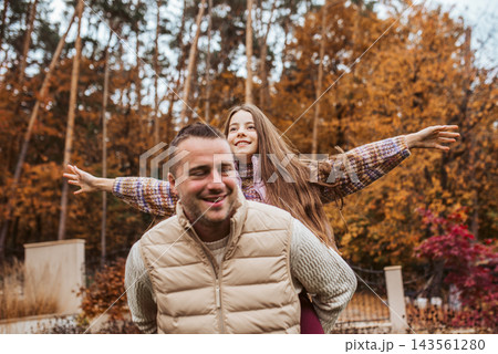 Father playing with daughter in autumn park. Father playing with daughter in autumn park. 143561280